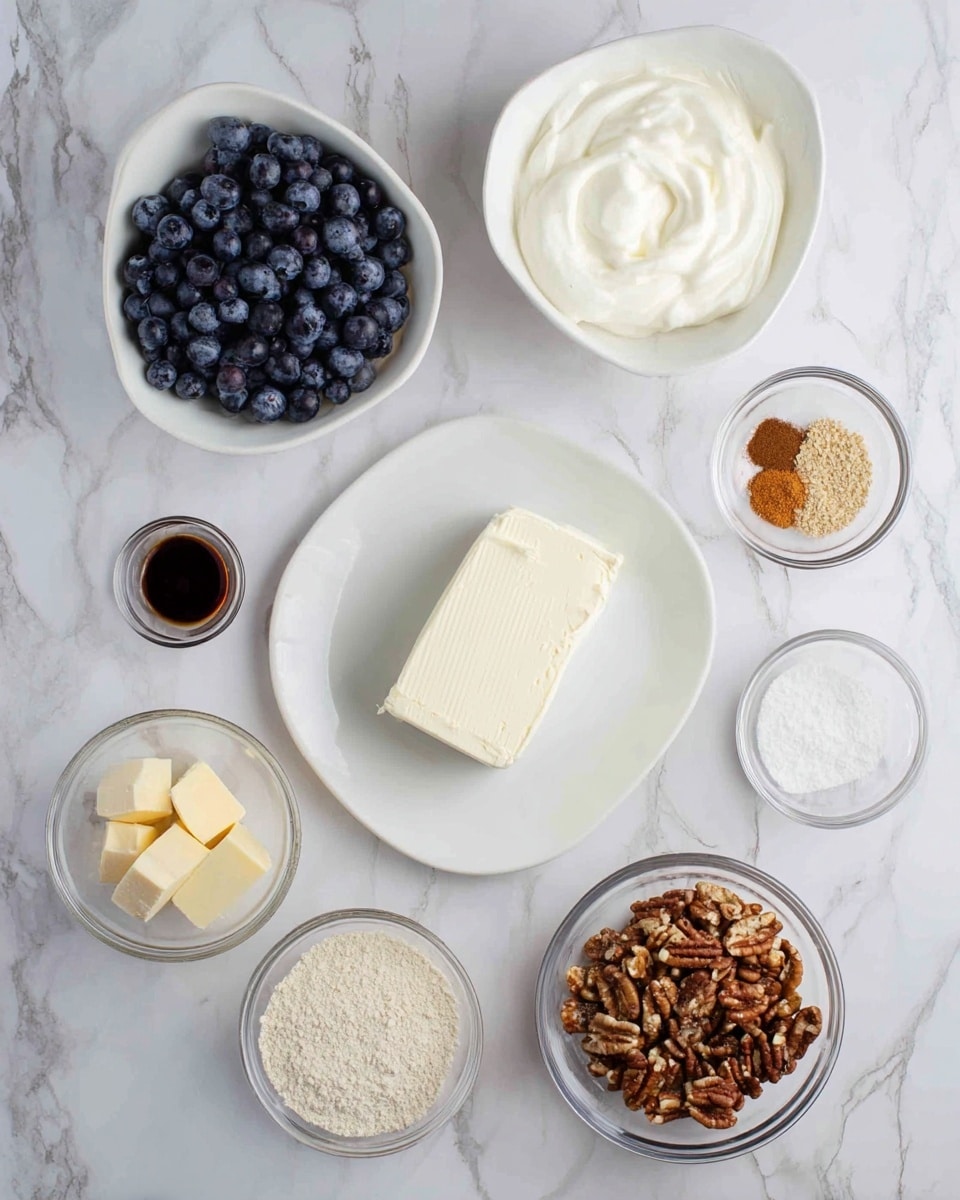The image shows several small bowls and a white plate arranged on a white marbled surface. The white plate in the center holds a solid block of cream cheese with a smooth, off-white texture. Around it, there is a white bowl full of fresh, dark blue blueberries at the top left. A white bowl at the top right contains thick, creamy white yogurt. A small glass bowl near the center top holds white granulated sugar. Below it is another glass bowl with a light brown powder, possibly flour or almond meal. At the bottom right, a glass bowl is filled with chopped pecans in various shades of brown. Next to it, another glass bowl holds a mixture of white sugar and cinnamon powder. There is also a small glass bowl with a pale yellow powder near the bottom left and a glass bowl with two cubes of pale yellow butter near the left side. A small glass container near the left side holds a dark liquid, likely vanilla extract. The setup is clean and bright with a neat, organized look. Photo taken with an iphone --ar 4:5 --v 7