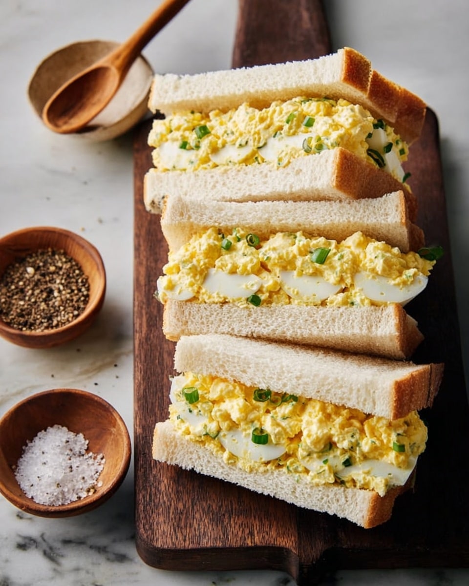 The image shows six tortilla wraps cut in half and arranged closely together on a white plate. Each wrap has three visible layers: the outer light beige tortilla, a middle layer of bright green fresh spinach leaves, and a thick inner layer of creamy light green chicken salad mixed with herbs and small chicken chunks. A couple of fresh basil leaves are placed on top of the wraps for garnish. The whole scene rests on a white marbled surface backdrop. photo taken with an iphone --ar 4:5 --v 7