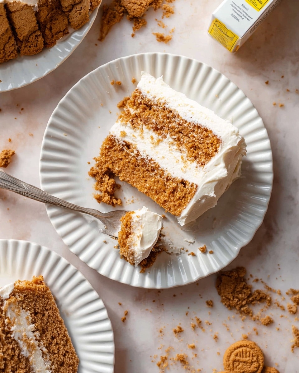 A white fluted plate holds a thick slice of three-layer light brown cake with a crumbly texture, each layer separated by smooth white frosting. A spoon on the right side of the plate holds a bite of the cake with the same layers visible, resting on the plate. Crumbs are scattered around the plate and on the white marbled surface underneath, with broken pieces of brown cookies nearby adding extra texture. Another white fluted plate with a similar cake slice is partially visible at the bottom. Photo taken with an iphone --ar 4:5 --v 7