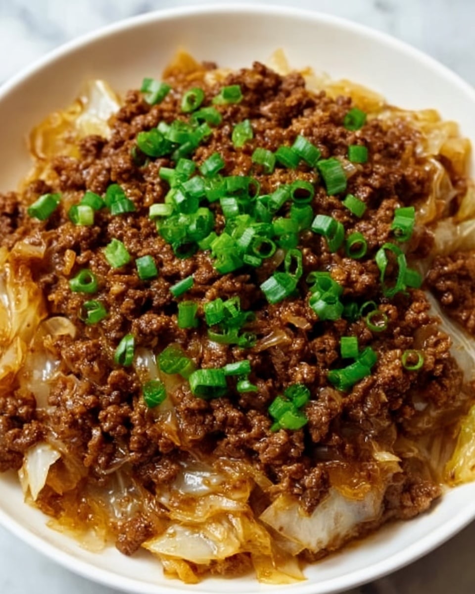 This image shows a close-up of a dish with two main layers in a white bowl. The bottom layer is made of cooked white cabbage pieces, soft and slightly translucent with a light brown sauce coating. On top is a thick layer of cooked minced beef, dark brown and crumbly in texture, mixed with some small green chopped onions scattered evenly all over, adding bright green color. The food looks moist and savory, sitting on a white marbled surface. Photo taken with an iphone --ar 4:5 --v 7