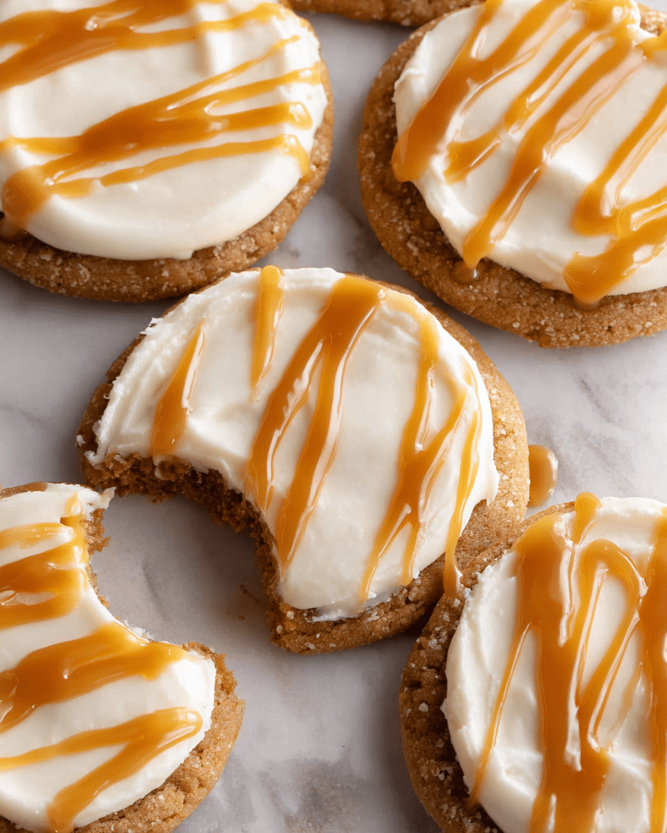 The image shows five round cookies arranged closely on a white marbled textured surface. Each cookie has a soft light brown base layer with a crumbly texture. On top, there is a thick layer of creamy white frosting with a smooth, slightly swirled texture. A glossy caramel sauce is drizzled over the frosting in a wavy striped pattern, adding a rich golden color contrast. One cookie is slightly tilted forward, showing a bite taken out, revealing the soft inside of the cookie and the thick frosting layer. Photo taken with an iphone --ar 4:5 --v 7