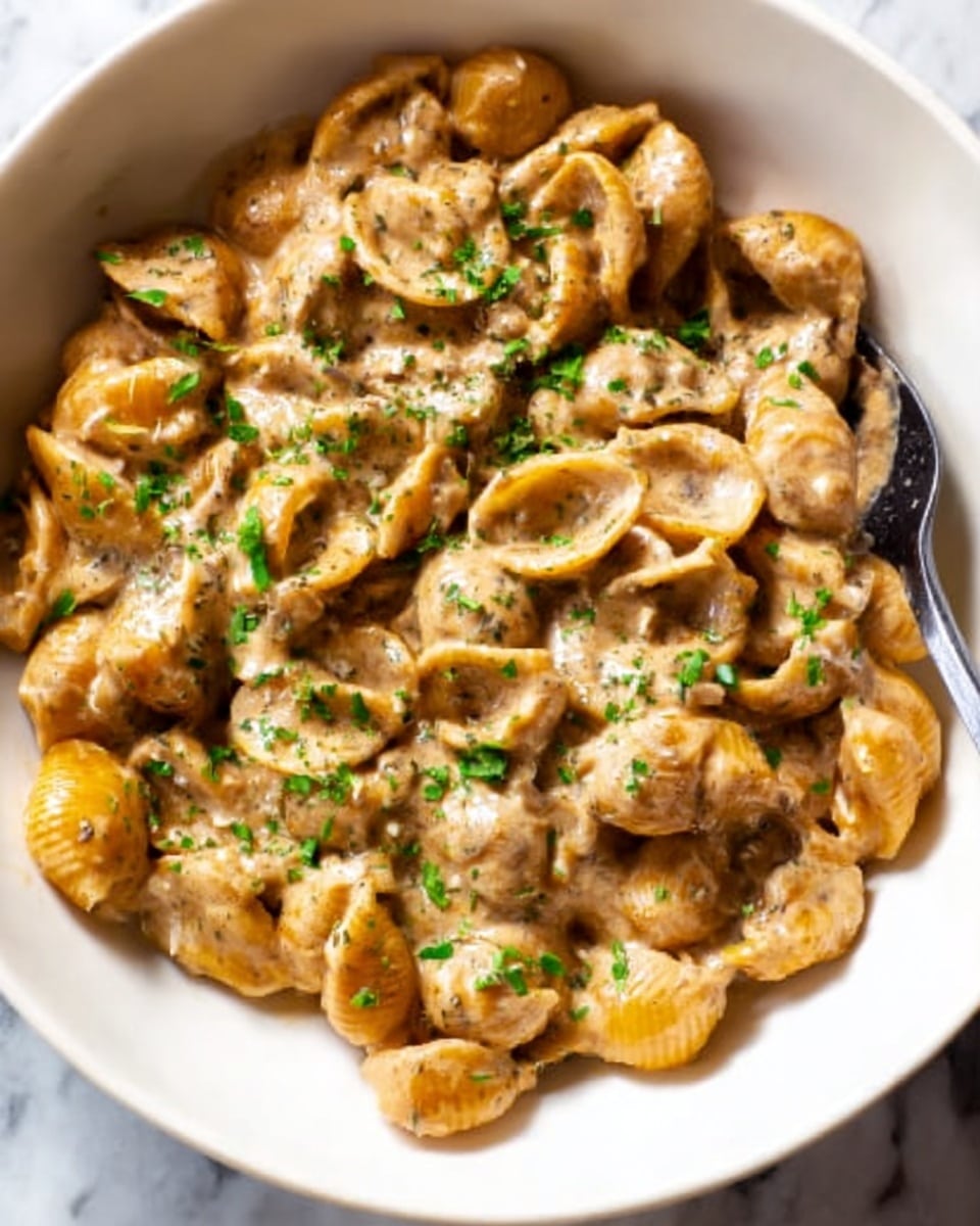 This image shows a close-up of a large pepperoni pizza cut into eight slices on a wooden board. The pizza has three visible layers: a golden-brown crispy crust, a layer of melted cheese that is slightly browned in spots, and a layer of round, shiny pepperoni slices topped with small green herb pieces and sprinkled with some white grated cheese. The pizza looks hot and fresh, with the cheese appearing stretchy and gooey. The background has a white marbled texture. photo taken with an iphone --ar 4:5 --v 7