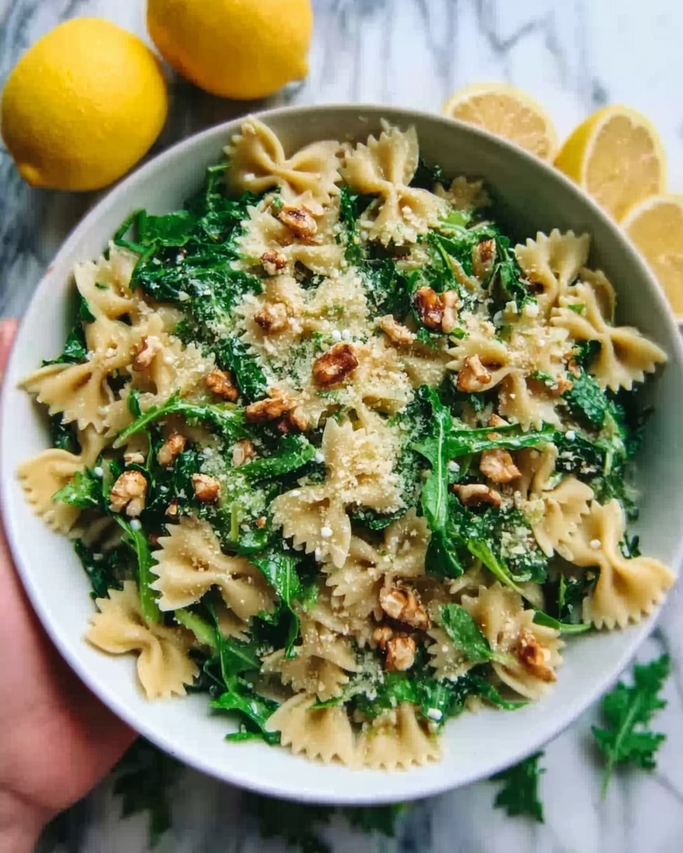 The image shows a white bowl filled with farfalle pasta mixed with green leafy arugula and sprinkled with small walnuts and grated cheese on top. The pasta is light yellow and the arugula is bright green, creating a fresh look. The bowl sits on a white marbled surface with two lemons and more arugula leaves around it, adding a vibrant touch. A woman's hand is holding a fork above the bowl, ready to take a bite. photo taken with an iphone --ar 4:5 --v 7