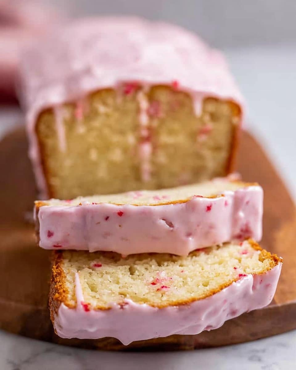A loaf of cake is sliced into three thick pieces stacked vertically, each slice showing a moist, light yellow crumb with a smooth texture. The top of each slice is covered with a shiny, pale pink glaze speckled with small red bits, dripping slightly over the edges. The cake rests on a wooden board, with a white marbled surface in the background. The sides of the cake are golden brown, creating a nice contrast with the soft pink glaze and light cake inside. photo taken with an iphone --ar 4:5 --v 7